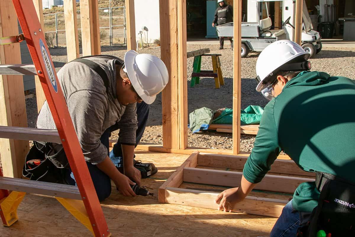 Two 火博体育 students working on framing a building