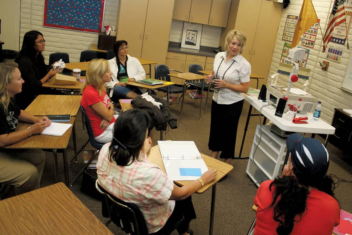 Pictured is an Instructor who got their degree in Teacher 教育 is instructing two students.